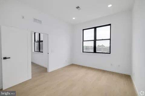an empty room with windows and closet