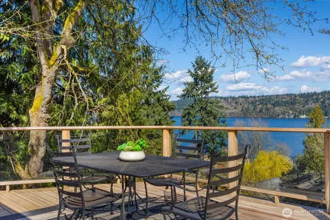 a balcony with wooden floor table and chairs