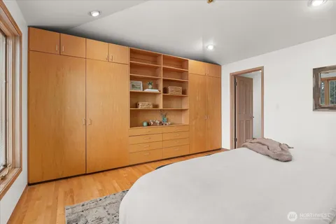 a bedroom with a bed and wooden floor