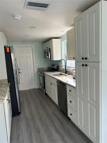 a kitchen with stainless steel appliances granite countertop a sink stove and refrigerator