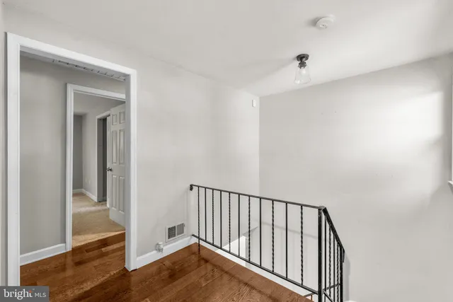 a view of a hallway with wooden floor and entryway