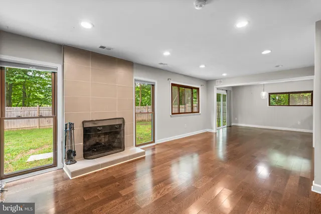 an empty room with windows and fireplace
