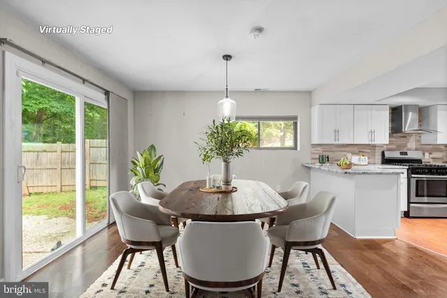a dining room with furniture a potted plant and a chandelier