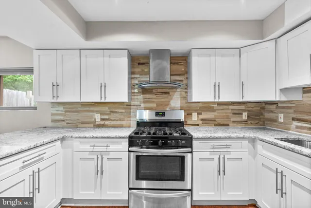 a kitchen with granite countertop white cabinets and stainless steel appliances