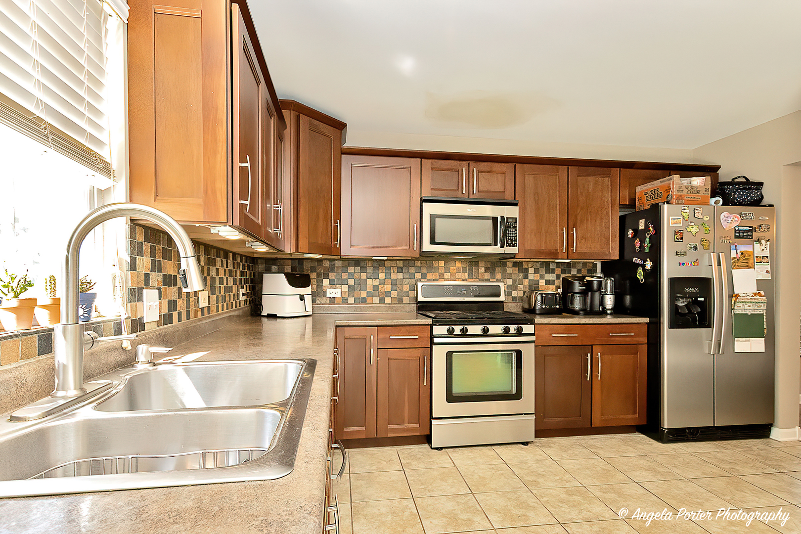 4025 Ridge Court Zion, IL 60099 - Photo 9 of 33 a kitchen with stainless steel appliances granite countertop a refrigerator a stove top oven and a sink with granite countertops