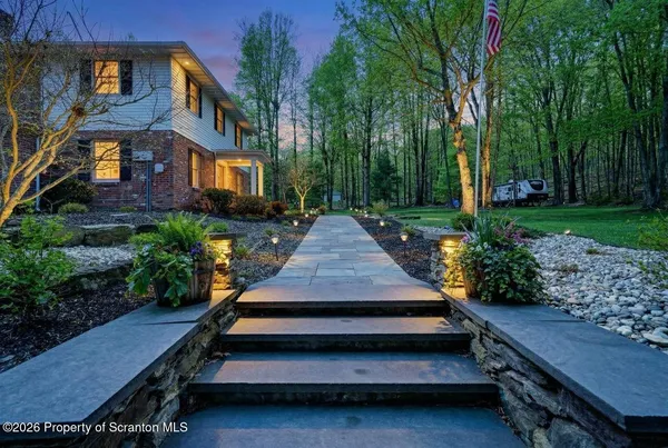 a open kitchen with stainless steel appliances granite countertop a refrigerator a sink dishwasher a dining table and chairs with wooden floor