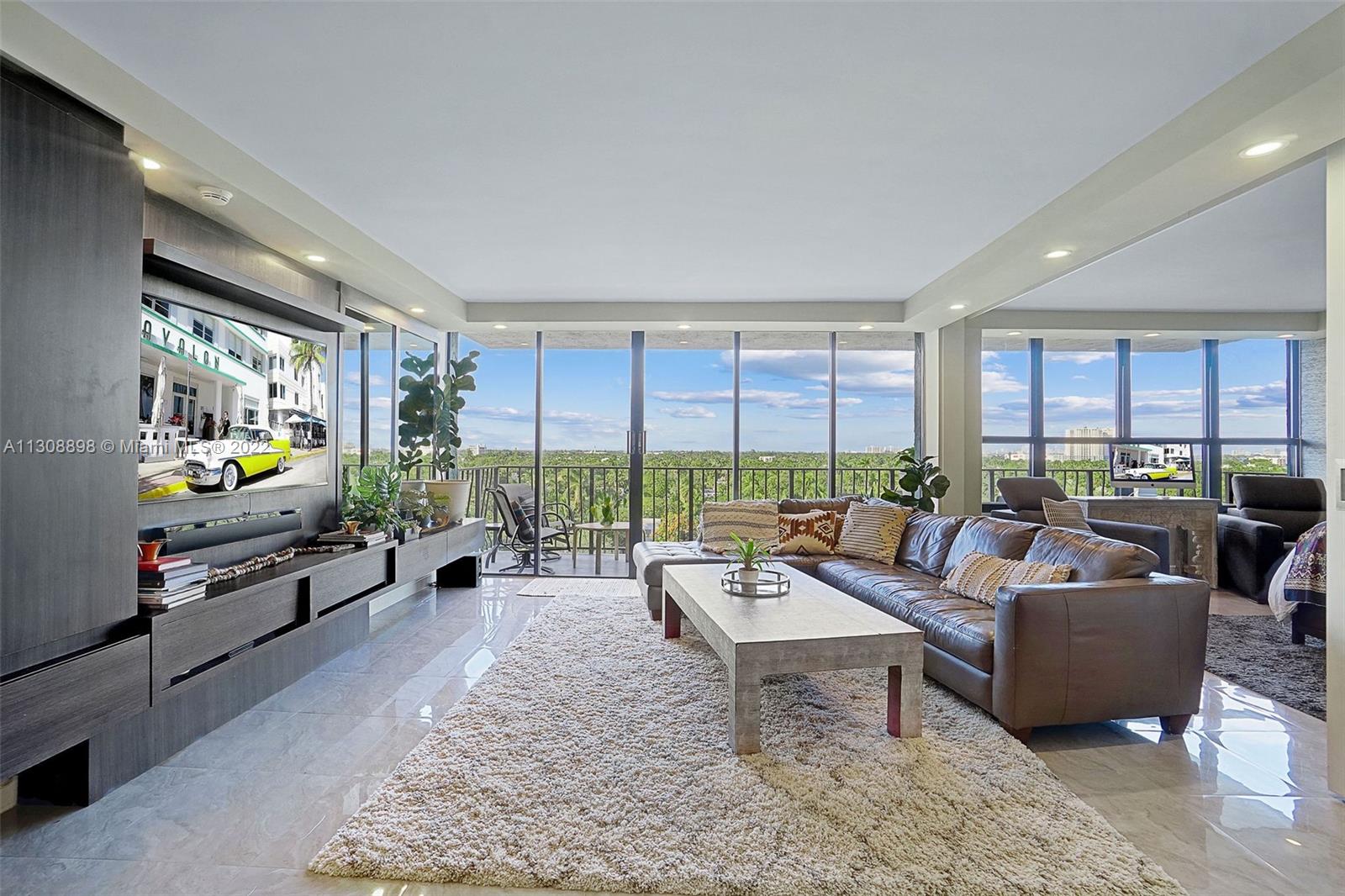 780 Northeast 69th Street, Unit 804 Miami, FL 33138 - Photo 4 of 22 a living room with furniture and a flat screen tv