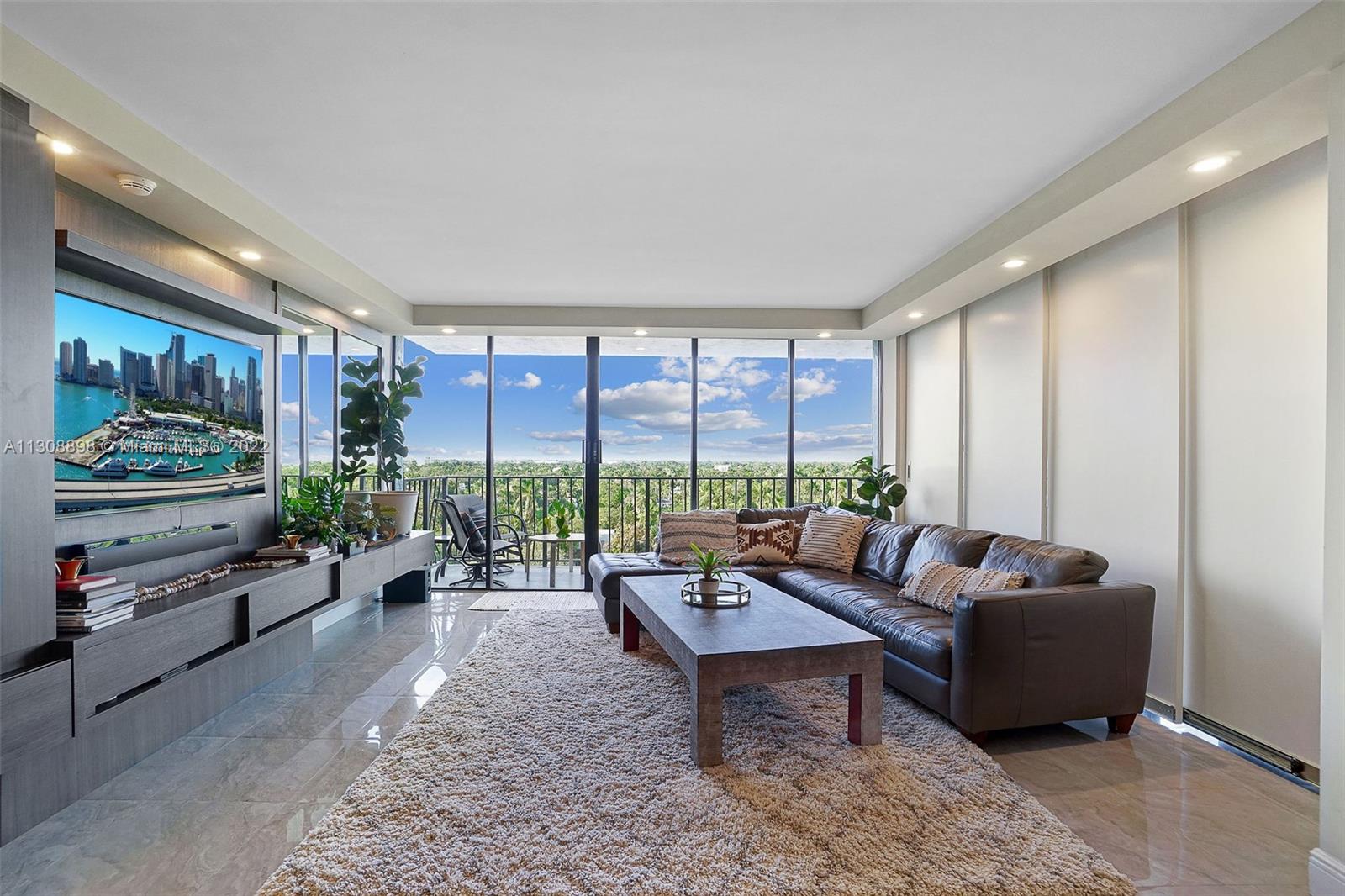 780 Northeast 69th Street, Unit 804 Miami, FL 33138 - Photo 5 of 22 a living room with furniture tv and a large window