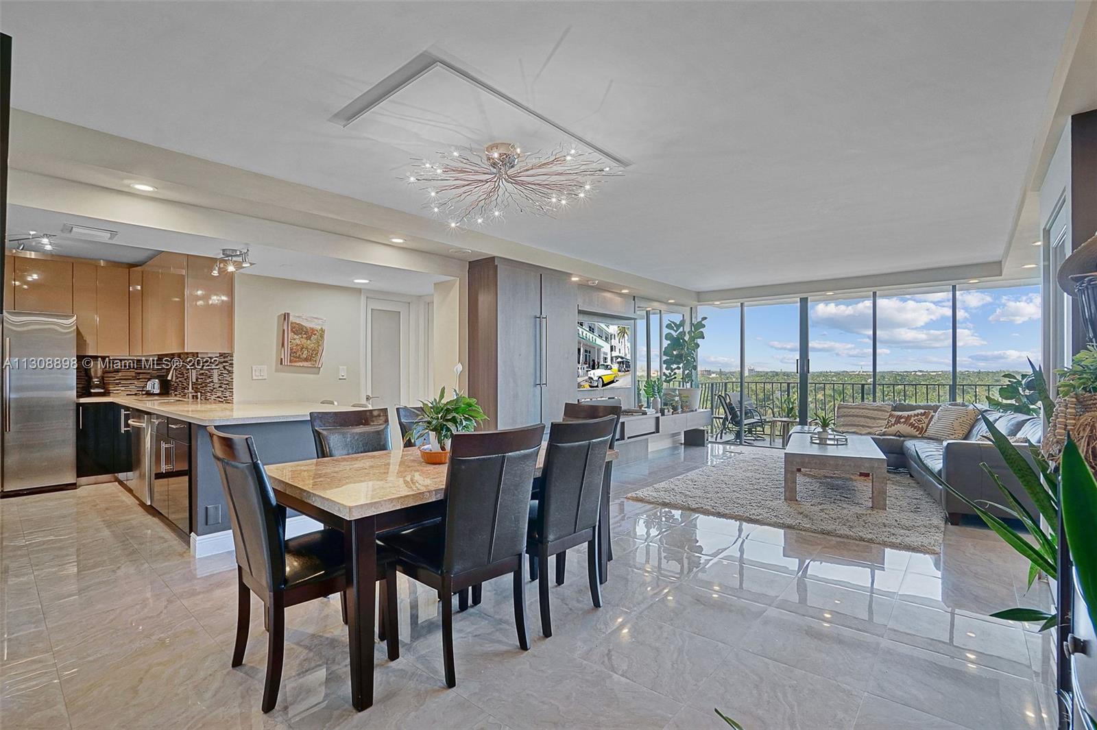 780 Northeast 69th Street, Unit 804 Miami, FL 33138 - Photo 6 of 22 a view of a dining room and livingroom with furniture a rug a potted plant and a chandelier