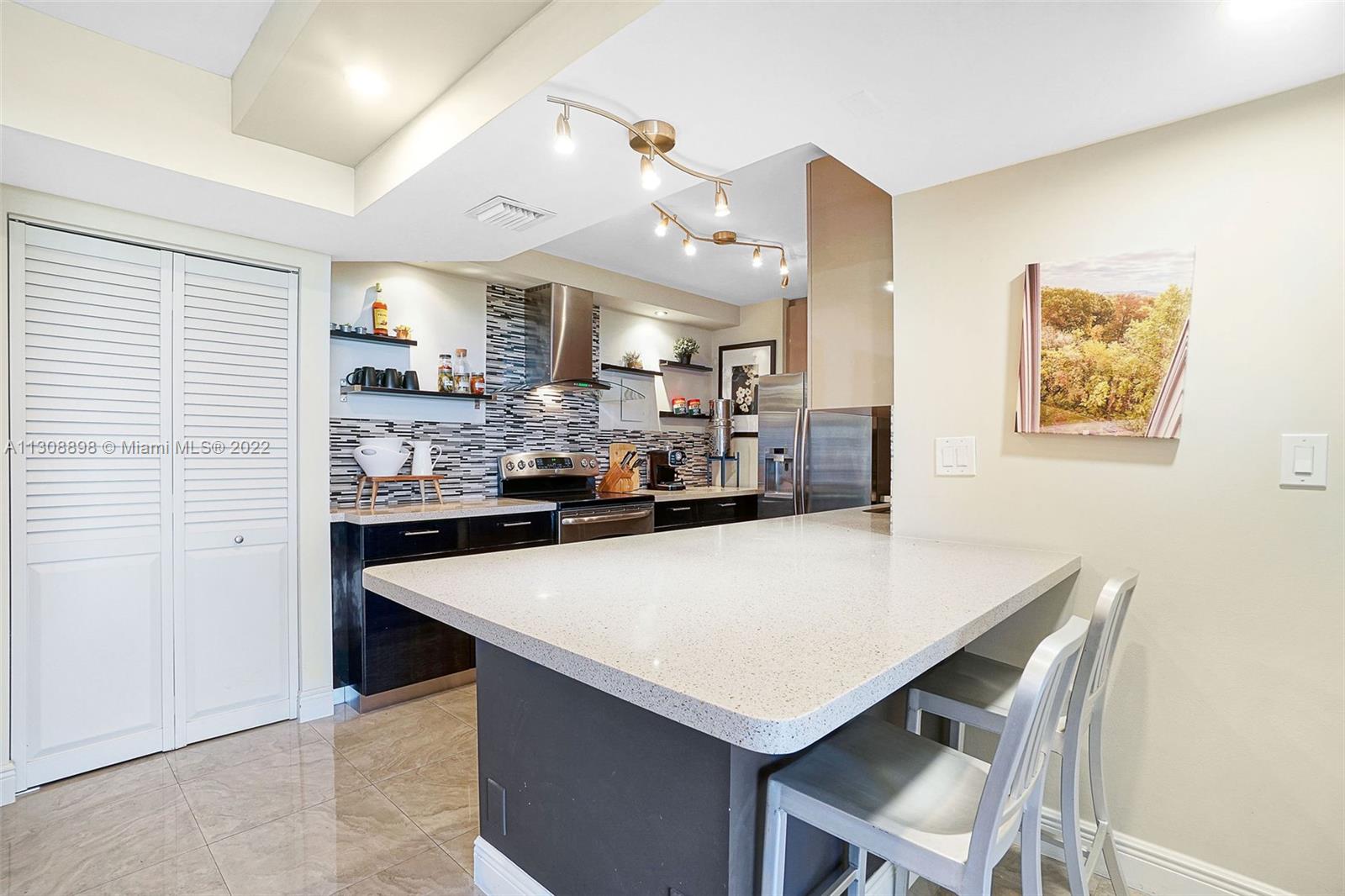 780 Northeast 69th Street, Unit 804 Miami, FL 33138 - Photo 8 of 22 a view of kitchen island and living room