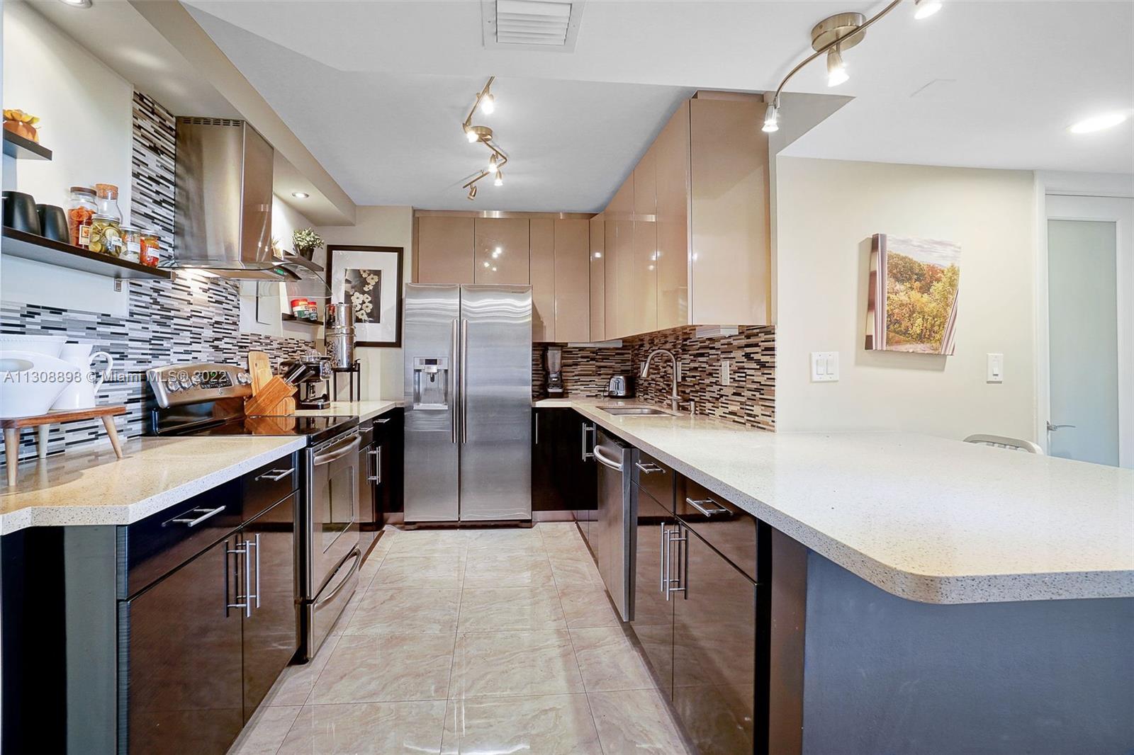 780 Northeast 69th Street, Unit 804 Miami, FL 33138 - Photo 9 of 22 a kitchen with stainless steel appliances a sink and stove