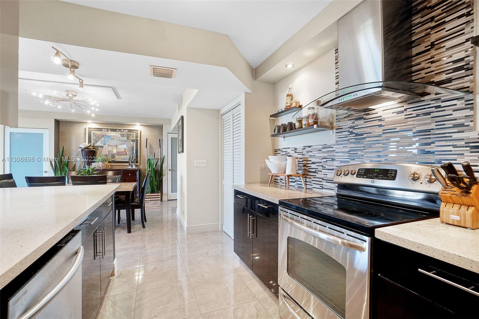 780 Northeast 69th Street, Unit 804 Miami, FL 33138 - Photo 10 of 22 a kitchen with a stove and cabinets