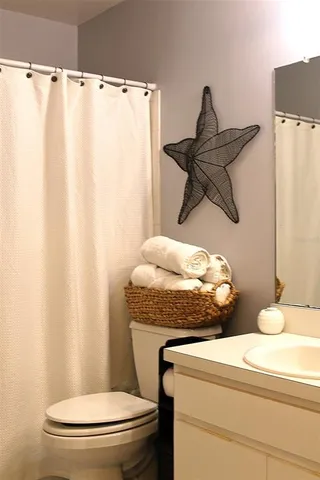 a bathroom with a granite countertop toilet and a sink