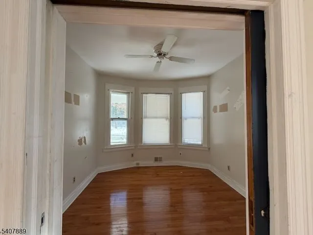 view of an empty room with wooden floor and a window