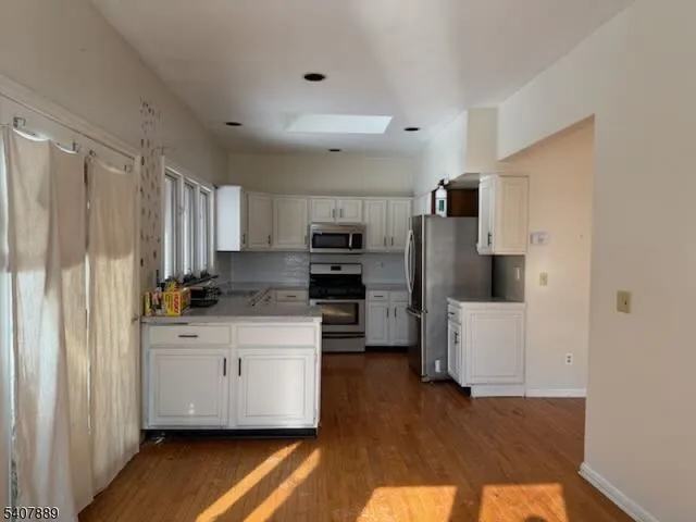 a walk in closet with wooden floor