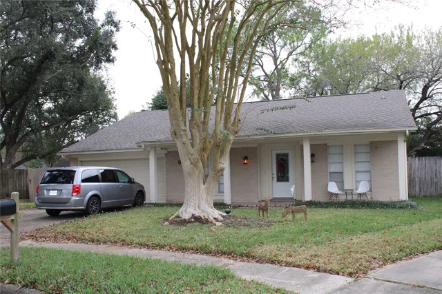 a front view of a house with a garden and trees
