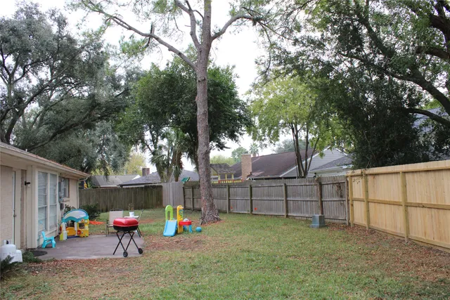 a backyard of a house with plants and wooden fence