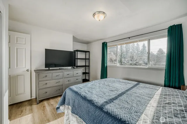 a bedroom with a large bed and a flat screen tv