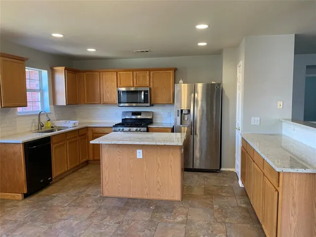a kitchen with kitchen island a sink stove and refrigerator