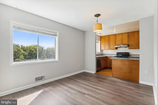 a kitchen with granite countertop a stove a sink and a window