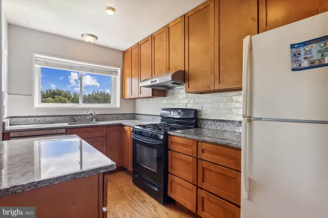 a kitchen with stainless steel appliances granite countertop a stove a refrigerator and a sink