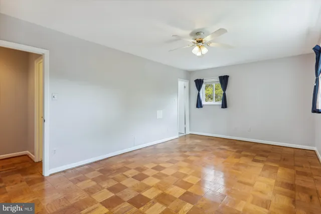 a view of a big room with windows and chandelier fan