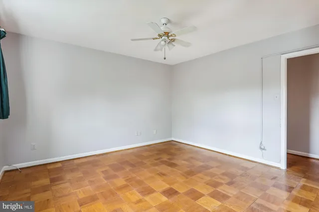 an empty room with a chandelier fan and closet