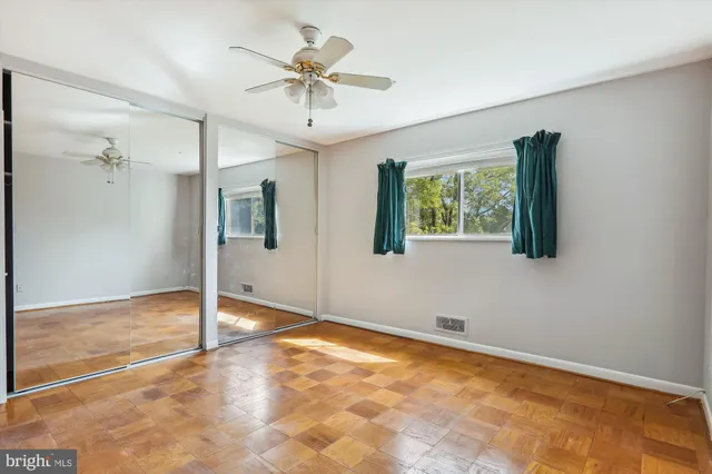 a view of an empty room with a chandelier fan