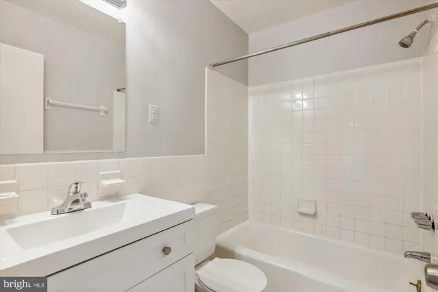 a bathroom with a sink mirror vanity and toilet