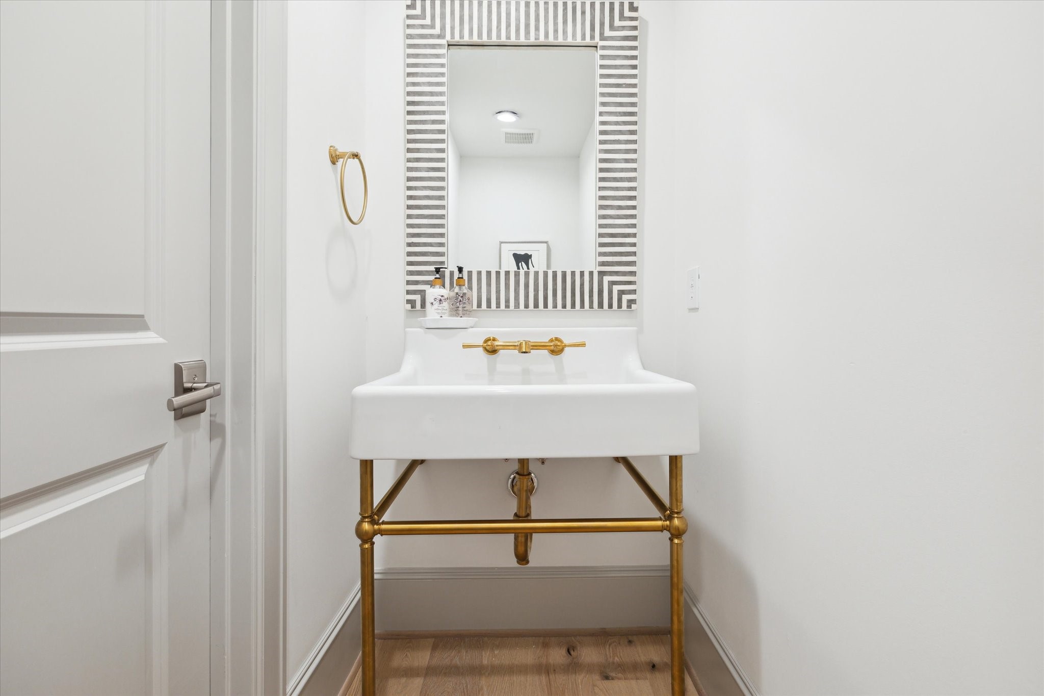 207 Sutton Row Place Houston, TX 77024 - Photo 9 of 29 Powder Bath features console sink with brass details.