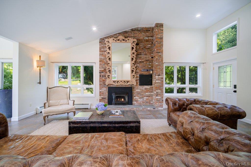 237 Mineral Springs Road Highland Mills, NY 10930 - Photo 10 of 32 Living area featuring healthy amount of natural light, high vaulted ceiling, a brick fireplace, and a baseboard heating unit