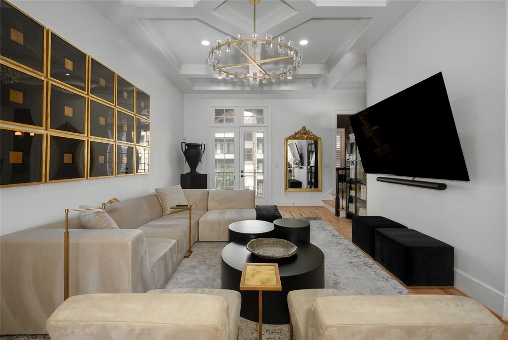 a living room with furniture a flat screen tv and a chandelier