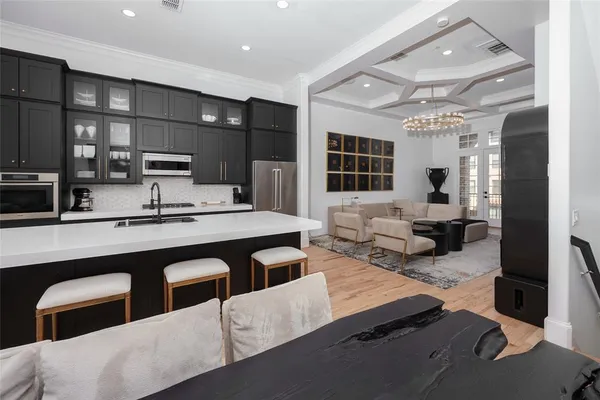 a large kitchen with a table chairs sink and cabinets