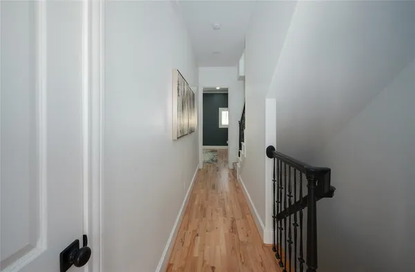 a view of a hallway with wooden floor and staircase