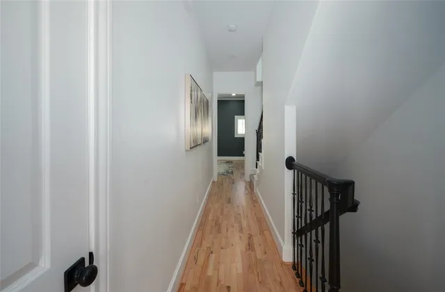 a view of a hallway with wooden floor and staircase