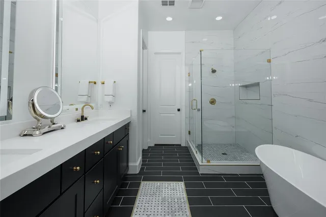 a bathroom with a sink a toilet a mirror and shower