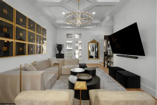 a living room with furniture a flat screen tv and a chandelier