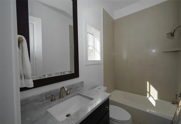 a bathroom with a sink vanity mirror and toilet