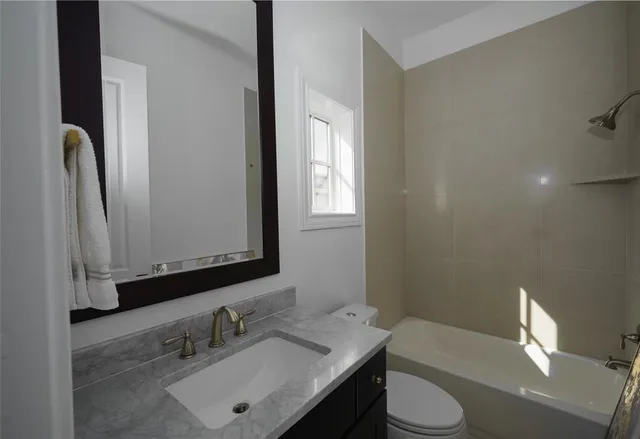 a bathroom with a sink vanity mirror and toilet