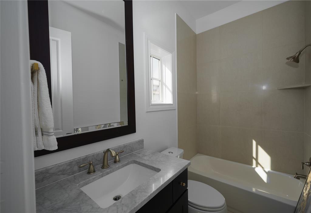727 Will Rice Avenue Irving, TX 75039 - Photo 25 of 26 a bathroom with a sink vanity mirror and toilet
