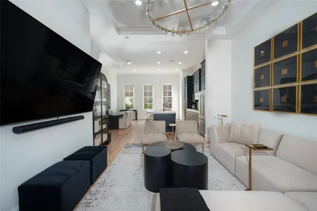 a living room with furniture a flat screen tv and kitchen view
