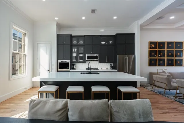 a dining hall with couches a flat tv screen and a dining table with wooden floor