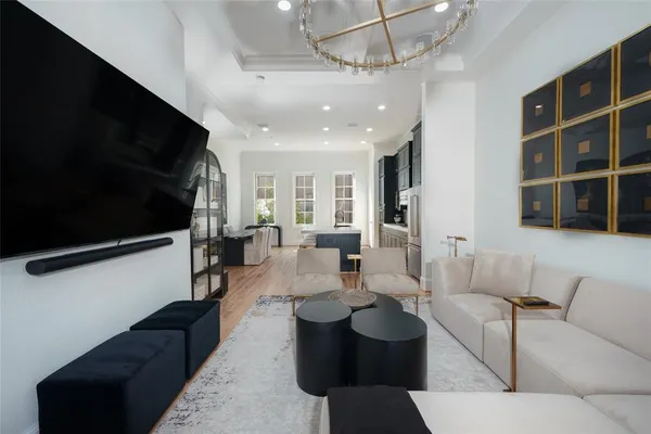a living room with furniture a flat screen tv and kitchen view