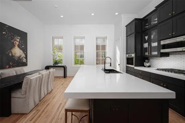 a large kitchen with kitchen island a stove a sink a dining table and chairs