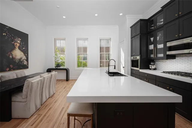 a large kitchen with kitchen island a stove a sink a dining table and chairs