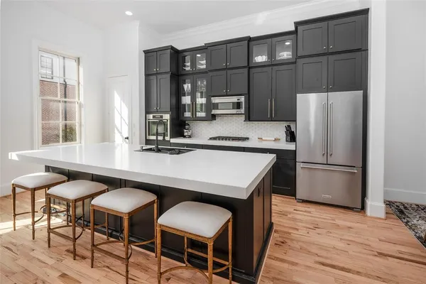 a kitchen with stainless steel appliances granite countertop a table chairs and a refrigerator