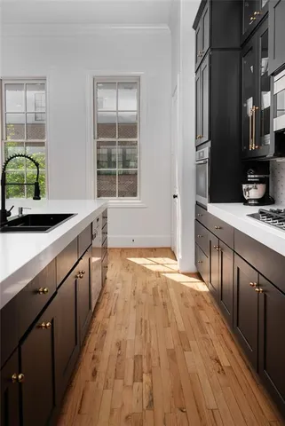 a kitchen with stainless steel appliances granite countertop a sink and wooden floors