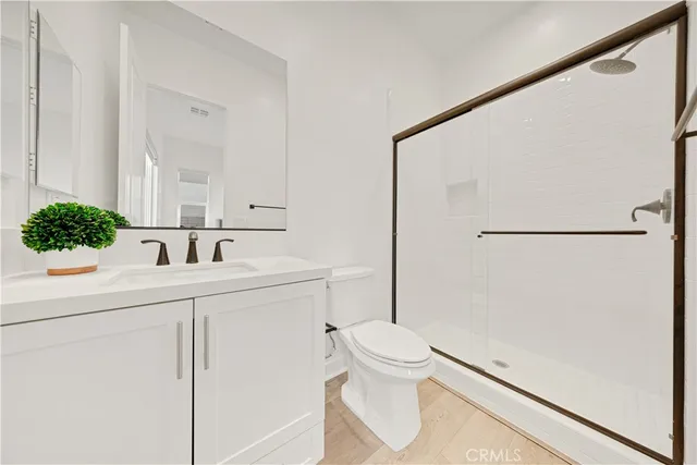 a bathroom with a sink a toilet and shower