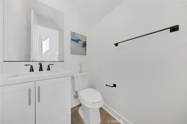 a bathroom with a toilet a sink a mirror and vanity