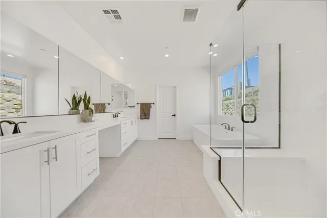 a large white bathroom with a sink a mirror and a shower
